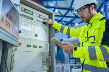 Electrical engineer woman checking voltage at the Power Distribution Cabinet in the control...