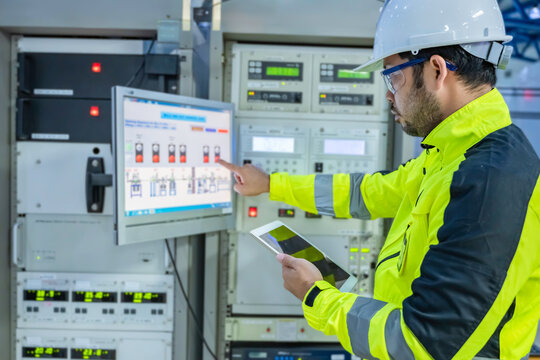 Electrical engineer woman checking voltage at the Power Distribution Cabinet in the control room,preventive maintenance Yearly,Thailand Electrician working at company