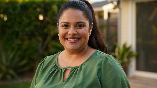 Smiling chubby housewife posing at her home backyard looking at the camera