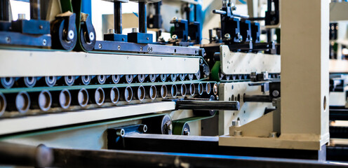 A industrial commercial envelope making machine, making paper envelopes for international distribution. Automated engineering machinery for mass production of paper envelopes.