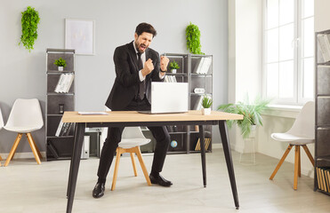 Happy celebration of victory, business achievement by businessman with winning gesture and crazy...