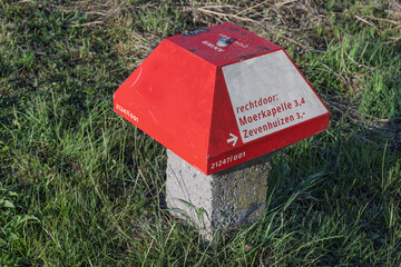 A close-up of a red and white ANWB signpost 