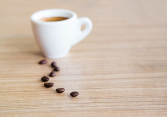 Cup of espresso coffee with coffee beans on the table, Artistic selective focus