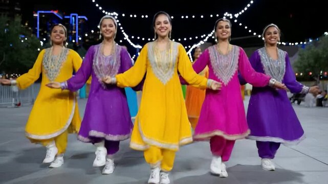 Five indian dancers performing traditional dance outdoors at night