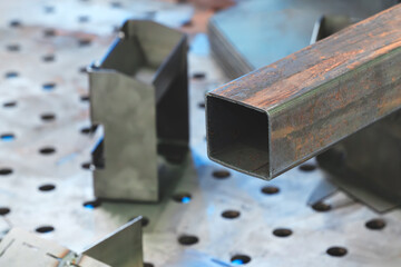 A pile of rusty metal parts, including cut pipes and elbows, the scene represents one of decay and an abandoned industrial. concept.