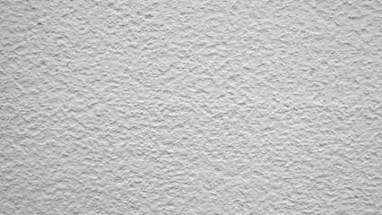 White wall with a rough texture. The wall is covered in white paint. The wall is not very smooth