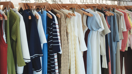 Rack of clothes with a green shirt on the left. There are many different colors of shirts and...