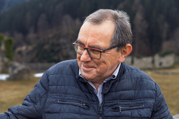 Elderly caucasian male smiling outdoors in winter jacket