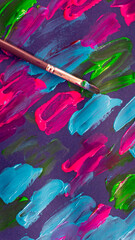 Fondo pintado con pintura acrílica colores vibrantes y un pincel encima