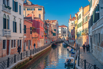 Venice and its narrow streets with canals and colorful houses.