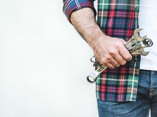 Attractive man, spanners and work clothes. Labor day. Front view, close up, studio shot. Labor and...