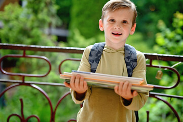 Caucasian boy carrying stack of books
