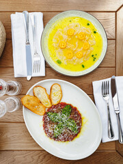 Fresh sea bream carpaccio with salad and tuna or beef tartar with pesto sauce and parmesan cheese....