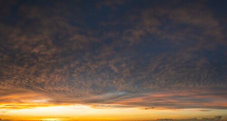 Beautiful sunset sky scenery. Bright colorful orange and yellow clouds on horizon