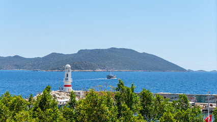 View of lighthouse and yachts in marina of town Kas, Turkey. Active recreation and boat trips in Mediterranean Sea