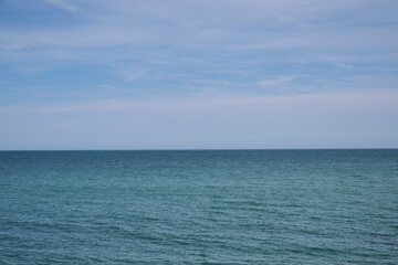 View of the calm ocean water extending to the horizon below a clear blue sky.