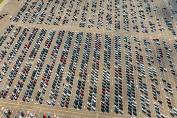 Obraz premium New cars parked on automotive factory parking lot for worldwide export. Dealer vehicle inventory business commercial