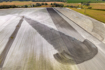 Sprinkler irrigation system watering farm field during dry season. Spraying water on farmland...
