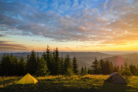 Tourist camping tent on mountain campsite at bright sunny evening. Active tourism and hiking concept
