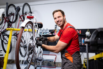 Experienced bicycle repairman servicing bike in workshop.