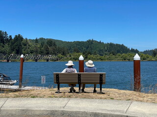 Couple sitting on a bench relaxing and enjoying a peaceful view of the Umpqua River