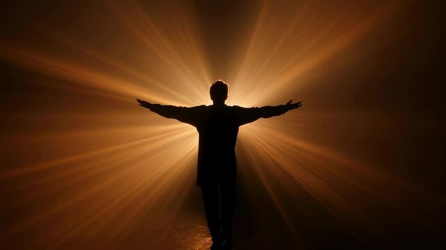 Silhouette of a man standing with open arms, embracing bright golden light beams emerging from the fog, creating a powerful image of hope, spirituality, and connection with the divine