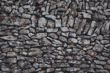 Intricate stone wall displaying the craftsmanship of traditional masonry in a serene rural setting during the golden hour of sunset