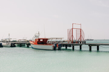 Beautiful boats docked at a serene pier on a calm sea during midday on a sunny day