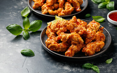 Korean fried chicken with spicy sauce and sesame seeds