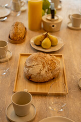 Petit déjeuner appétissant servi sur une élégante table en bois avec chaises en cannage, dans une salle lumineuse et chaleureuse.
