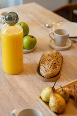 Petit déjeuner appétissant servi sur une élégante table en bois avec chaises en cannage, dans une salle lumineuse et chaleureuse.