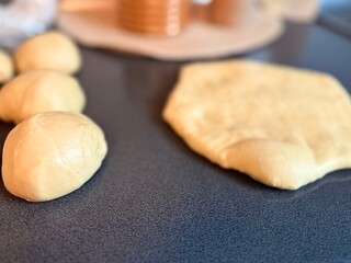 The girl rolls out the dough with a wooden rolling pin for making cupcakes or cookies. Flat composition with kitchen utensils and ingredients, copy space. Concept of baking for the holiday. 