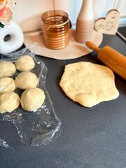 The girl rolls out the dough with a wooden rolling pin for making cupcakes or cookies. Flat composition with kitchen utensils and ingredients, copy space. Concept of baking for the holiday. 