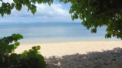La plage de sable blanc et la mer turquoise sous le ciel bleu