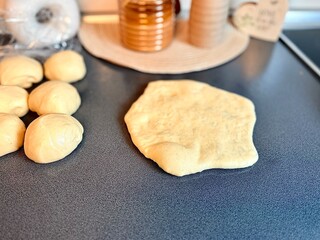 The girl rolls out the dough with a wooden rolling pin for making cupcakes or cookies. Flat composition with kitchen utensils and ingredients, copy space. Concept of baking for the holiday. 