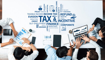 A group of financial advisors collaboratively analyze tax strategies and data in a corporate...