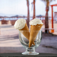 Ice cream on a wooden table by the beach – summer treat, dessert and seaside refreshment concept. Advertising summer desserts, beach snacks, travel, and lifestyle brands themes.