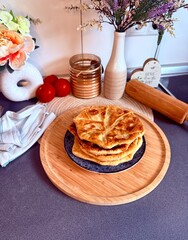 Romanian and Moldovan pies are fried in a large frying pan. Traditional homemade round pies - Placinta. Bakery products. Rustic style. Street Food Fair. Chisinau. Moldova. 