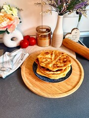 Romanian and Moldovan pies are fried in a large frying pan. Traditional homemade round pies - Placinta. Bakery products. Rustic style. Street Food Fair. Chisinau. Moldova. 