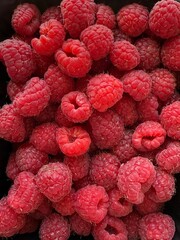 Close-up image of multiple fresh red raspberries. The berries are clean, ripe, and densely packed.