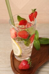 Tasty refreshing drink with strawberries, lemon and mint on wooden table, closeup