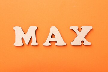 Word Max made of wooden letters on orange background, top view
