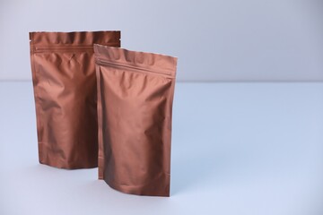 Two zipper stand-up pouches on light grey background. Mockup for design