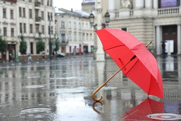 Red umbrella under heavy rain outdoors, space for text