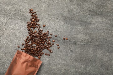 Zipper stand-up pouch and coffee beans on grey table, flat lay. Space for text