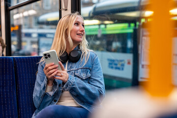 Young woman using smartphone while riding public transport