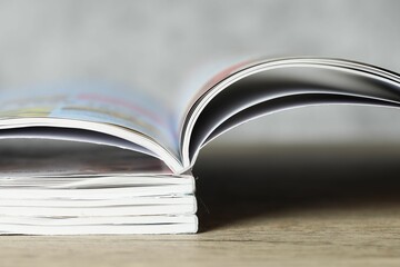 Stack of different magazines on wooden table, closeup
