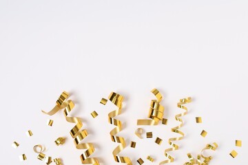 Shiny party streamers and confetti on white background, flat lay. Space for text