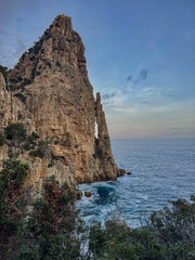 A tall, steep, rocky mountain rising directly from the sea.