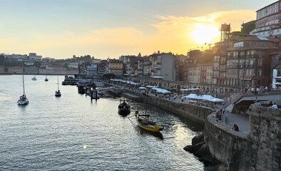 City on the river bank with yachts sunset over the river